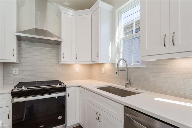 kitchen with sink, white cabinetry, backsplash, stainless steel appliances, and wall chimney exhaust hood