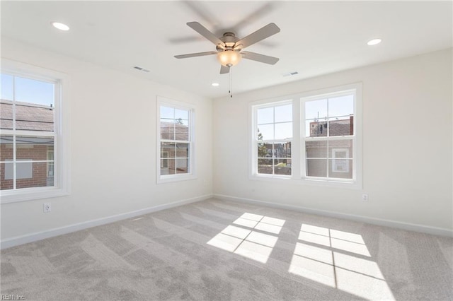 carpeted spare room featuring ceiling fan