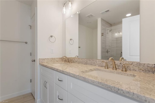 bathroom featuring an enclosed shower, vanity, and wood-type flooring