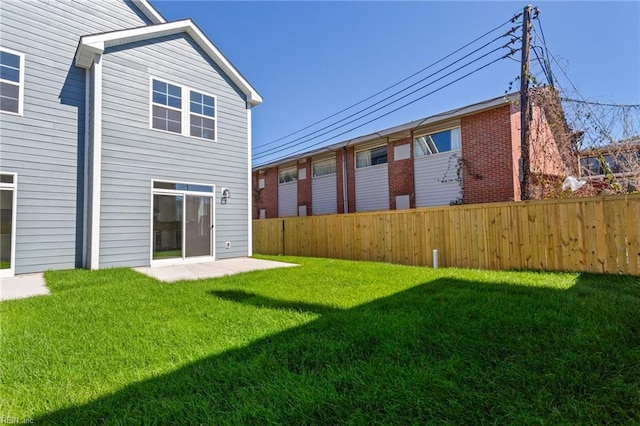 rear view of property with a lawn and a patio