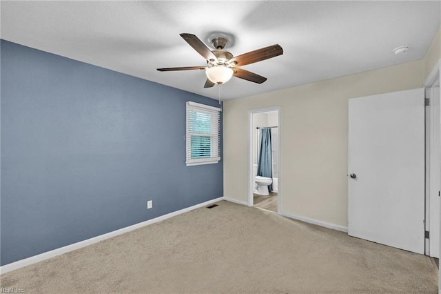 unfurnished bedroom with ceiling fan, ensuite bathroom, and light carpet