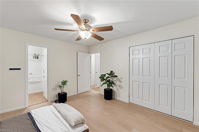 bedroom with connected bathroom, light hardwood / wood-style flooring, and a closet