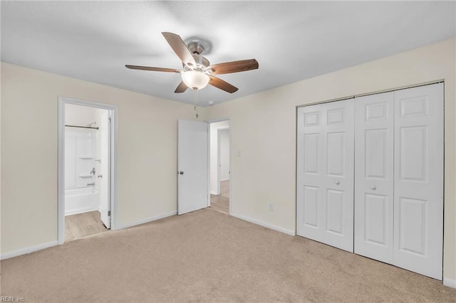 unfurnished bedroom featuring ceiling fan, light colored carpet, connected bathroom, and a closet