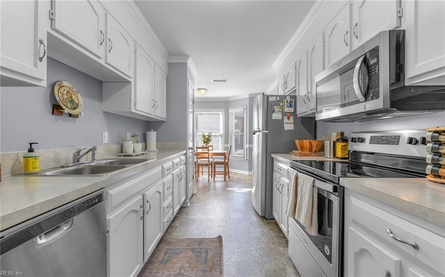 kitchen featuring white cabinetry, ornamental molding, stainless steel appliances, and sink