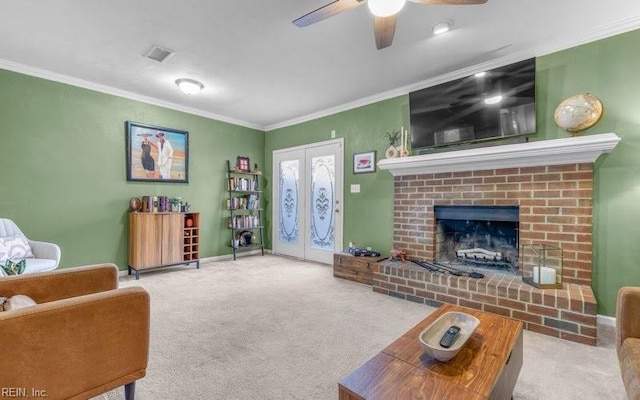 carpeted living room with a brick fireplace, crown molding, french doors, and ceiling fan