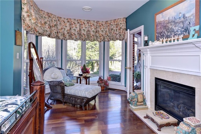 sitting room featuring a premium fireplace, dark hardwood / wood-style floors, and a wealth of natural light