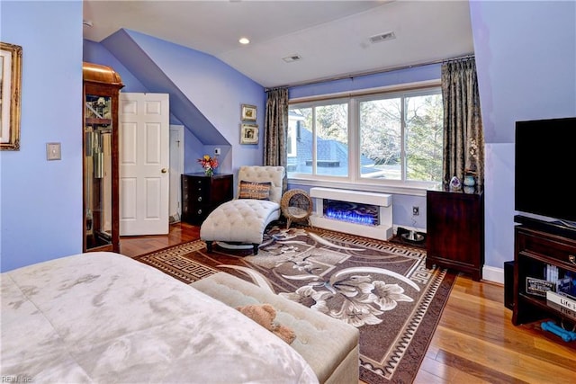 bedroom with hardwood / wood-style flooring and lofted ceiling