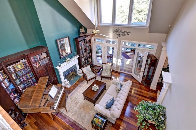 living room featuring a high ceiling, ceiling fan, dark hardwood / wood-style flooring, and french doors