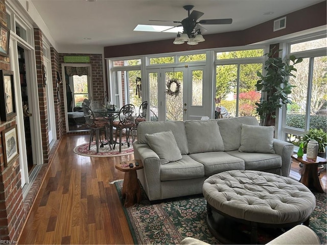 sunroom / solarium with ceiling fan and a skylight