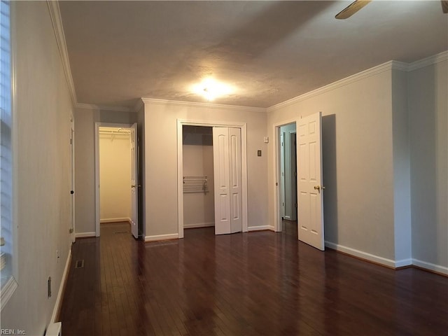 unfurnished bedroom with dark wood-type flooring, ornamental molding, and a closet