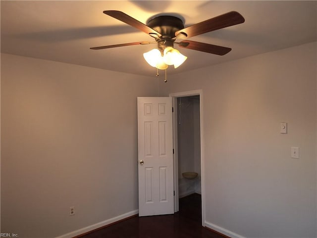 empty room featuring dark wood-type flooring and ceiling fan