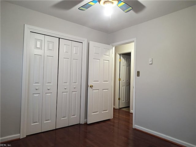 unfurnished bedroom featuring dark wood-type flooring, ceiling fan, and a closet