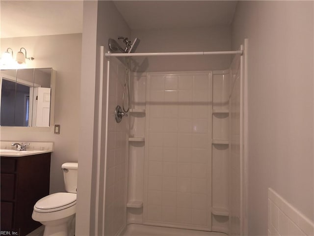 bathroom with vanity, toilet, and a shower