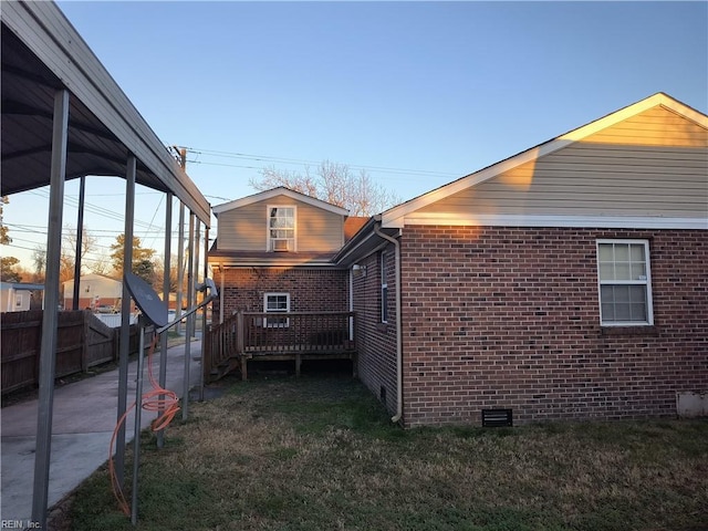 view of home's exterior with a deck and a lawn