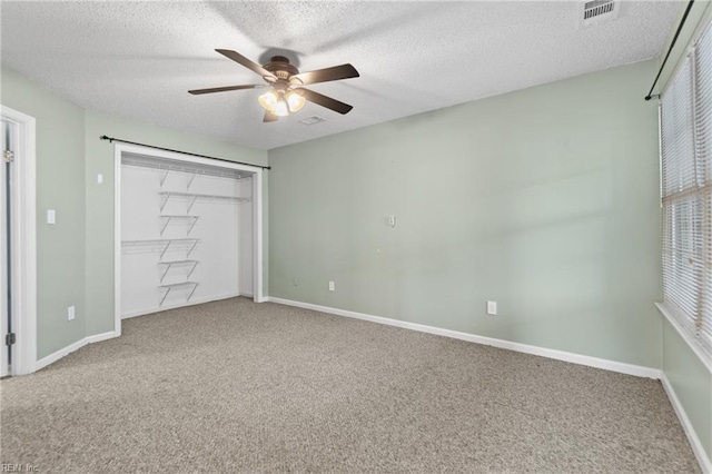 unfurnished bedroom featuring ceiling fan, a closet, a textured ceiling, and carpet