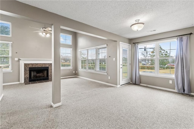 unfurnished living room featuring light carpet, ceiling fan, and a textured ceiling