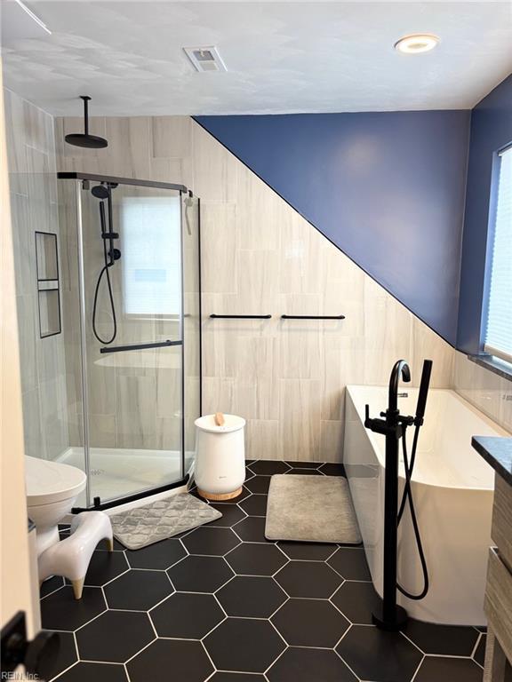 bathroom with vanity, an enclosed shower, and tile walls