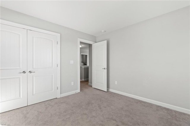 unfurnished bedroom featuring light carpet and a closet