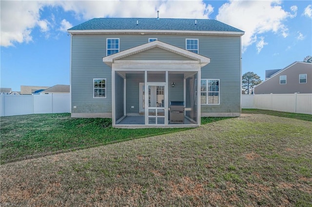 rear view of property with a sunroom, a patio area, and a lawn