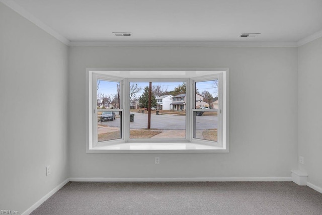 spare room with ornamental molding and carpet