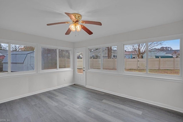 unfurnished sunroom with ceiling fan