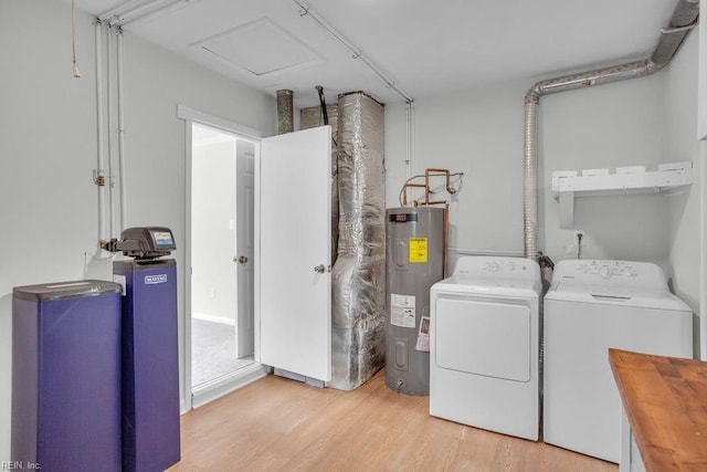 laundry room with washer and clothes dryer, electric water heater, and light wood-type flooring