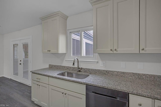 kitchen with white cabinetry, black dishwasher, sink, and light stone counters