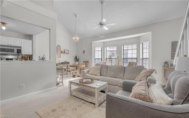 carpeted living room featuring ceiling fan, vaulted ceiling, and a textured ceiling