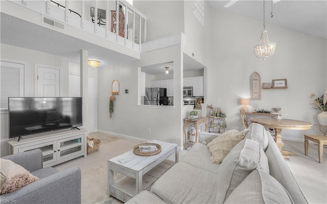 living room with a towering ceiling and a notable chandelier