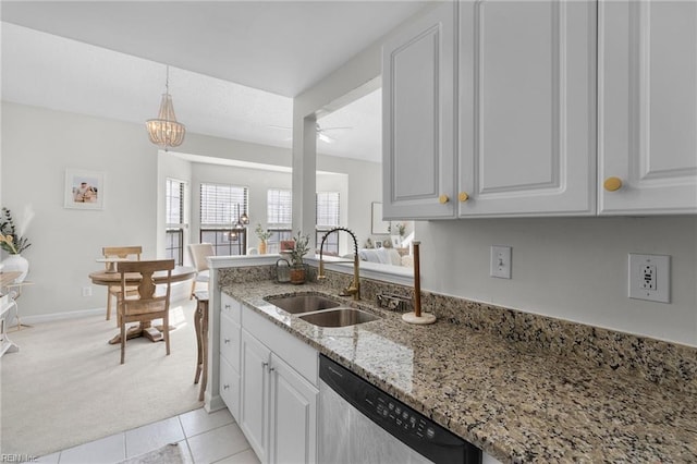 kitchen featuring sink, light stone counters, dishwasher, light colored carpet, and white cabinets