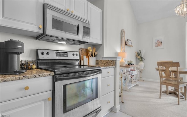 kitchen with white cabinetry, decorative light fixtures, stone counters, and appliances with stainless steel finishes