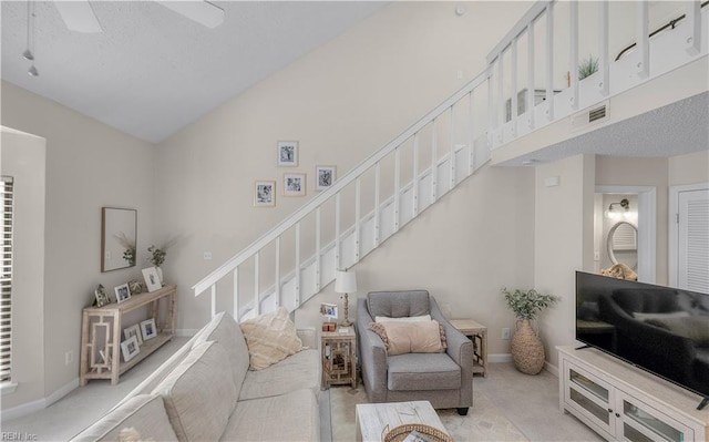 carpeted living room with high vaulted ceiling