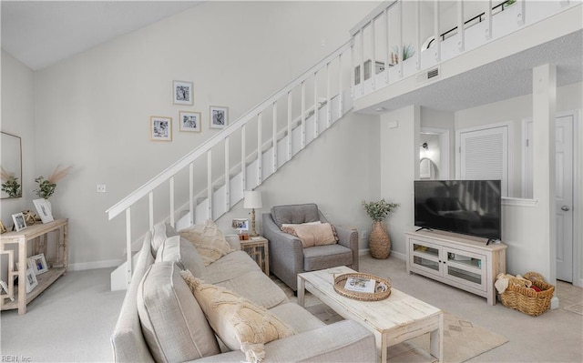 carpeted living room featuring a high ceiling