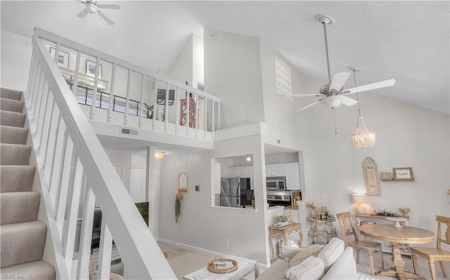 living room with ceiling fan and high vaulted ceiling