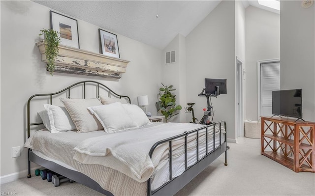 carpeted bedroom with high vaulted ceiling