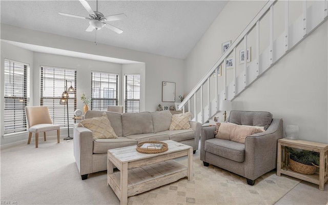 living room featuring vaulted ceiling, light carpet, a textured ceiling, and ceiling fan