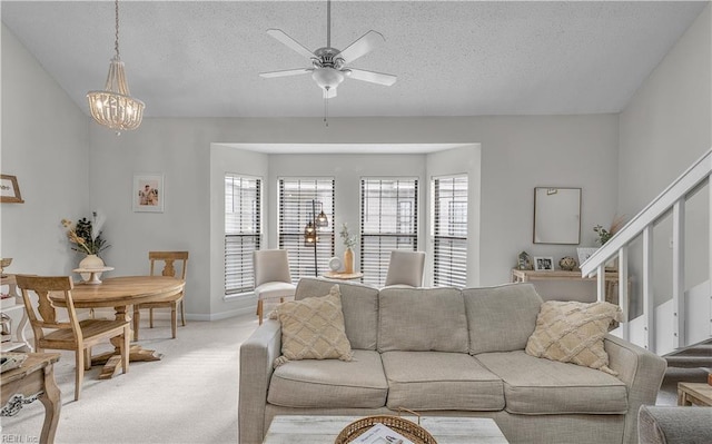 carpeted living room with vaulted ceiling, ceiling fan with notable chandelier, and a textured ceiling