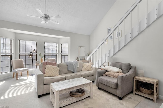 carpeted living room featuring lofted ceiling, ceiling fan, and a textured ceiling