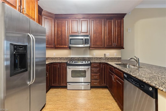 kitchen featuring dark stone countertops, sink, crown molding, and appliances with stainless steel finishes