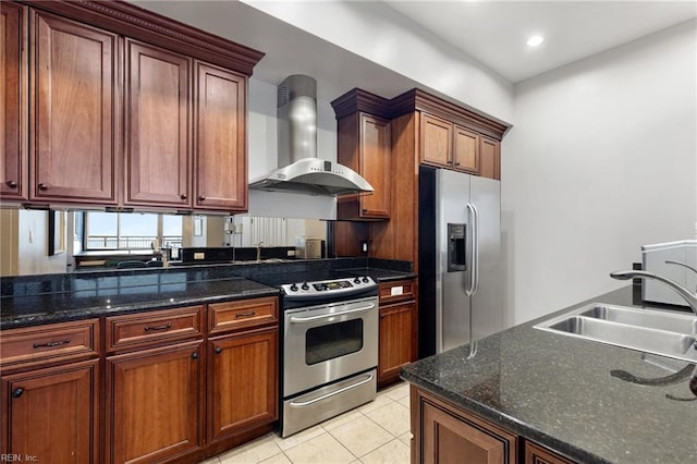 kitchen featuring wall chimney exhaust hood, sink, dark stone counters, light tile patterned floors, and stainless steel appliances