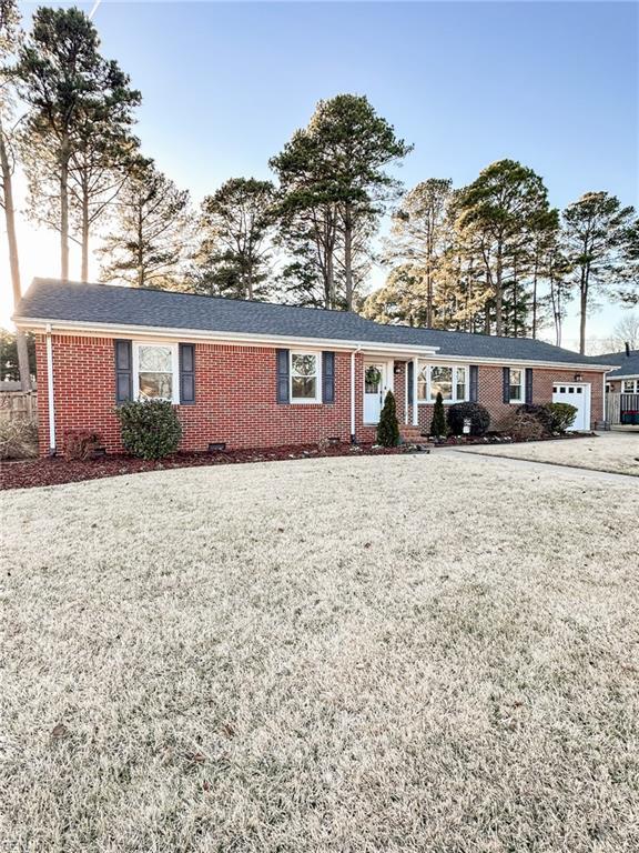 ranch-style home featuring a garage and a front lawn