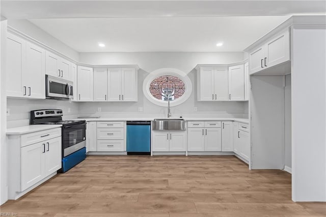 kitchen featuring stainless steel appliances, sink, light hardwood / wood-style flooring, and white cabinets