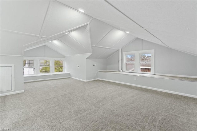 additional living space featuring vaulted ceiling and carpet