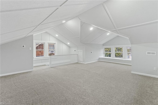 additional living space featuring vaulted ceiling and carpet