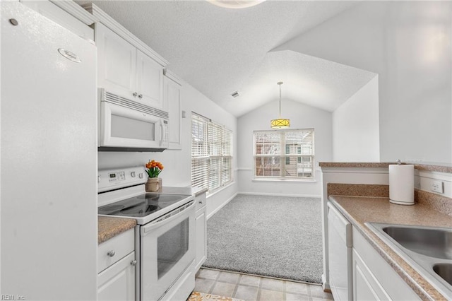 kitchen with vaulted ceiling, light carpet, hanging light fixtures, white appliances, and white cabinets