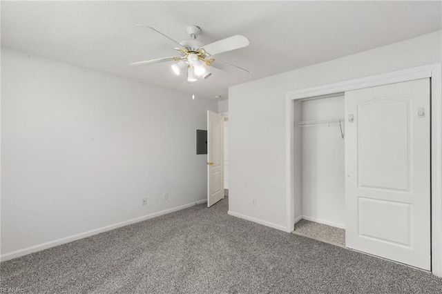 unfurnished bedroom featuring ceiling fan, a closet, electric panel, and carpet