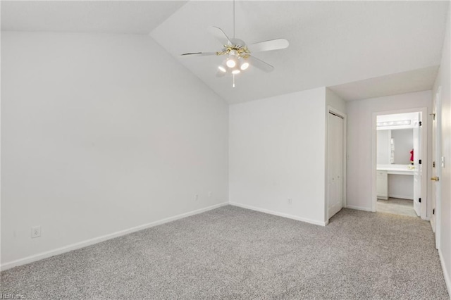 unfurnished bedroom with light carpet, connected bathroom, lofted ceiling, and ceiling fan