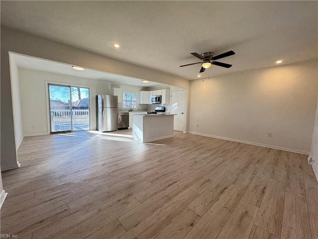 unfurnished living room with ceiling fan and light hardwood / wood-style floors