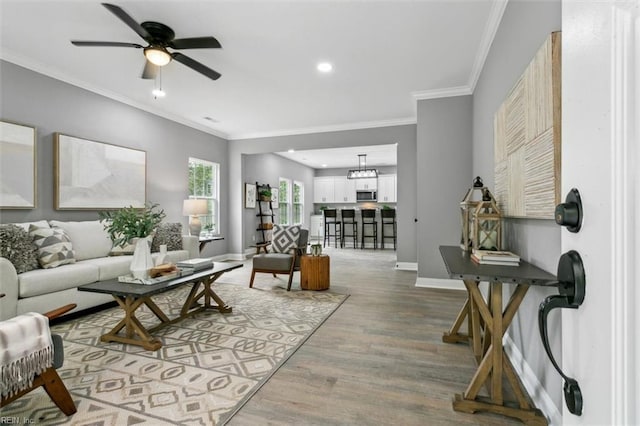 living room featuring ceiling fan, ornamental molding, and hardwood / wood-style floors