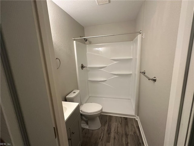 bathroom featuring hardwood / wood-style flooring, vanity, toilet, and walk in shower